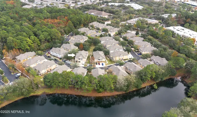an aerial view of a residential houses with outdoor space and trees