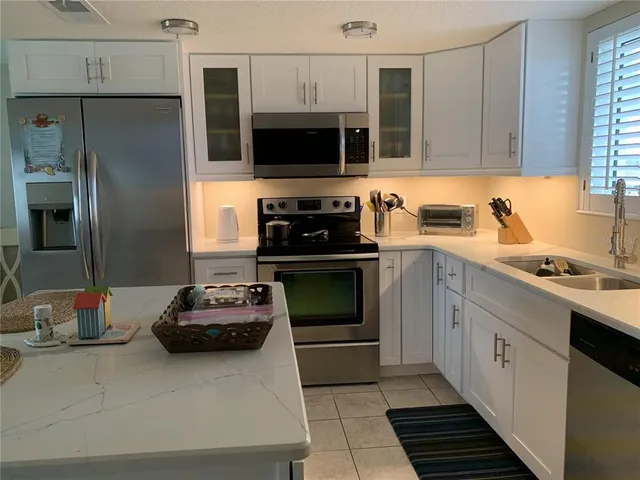 a kitchen with stainless steel appliances a stove a sink and a microwave