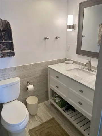 a bathroom with a granite countertop toilet sink and mirror