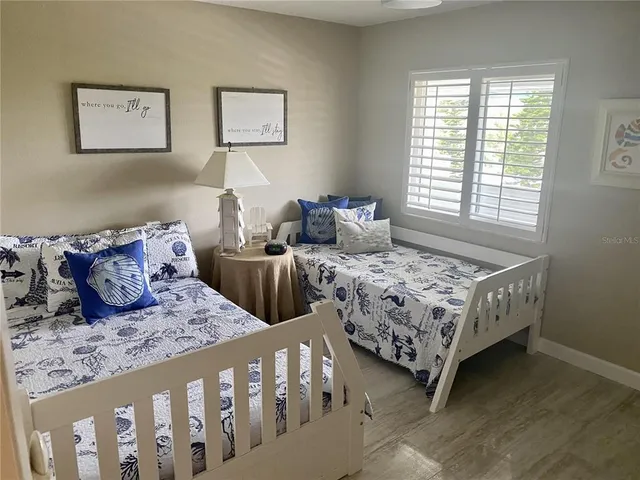 a bedroom with two beds and a large window