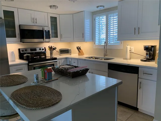 a kitchen with a sink a stove and a microwave