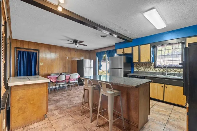 a kitchen with granite countertop sink stove and white cabinets