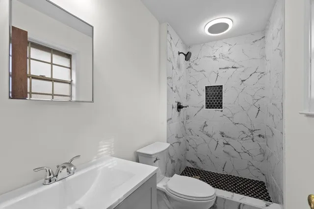 a bathroom with a sink a toilet and shower