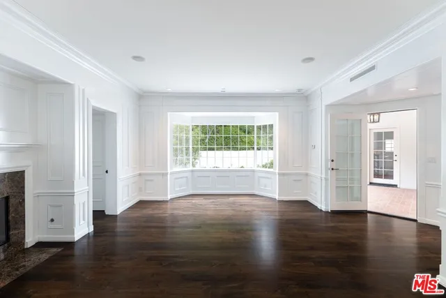 an empty room with wooden floor and fireplace