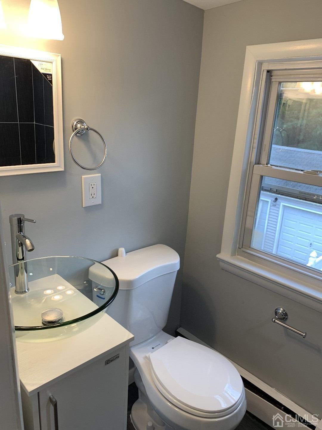 180 East Cliff Road Colonia, NJ 07067 - Photo 6 of 6 a bathroom with a toilet a sink and mirror