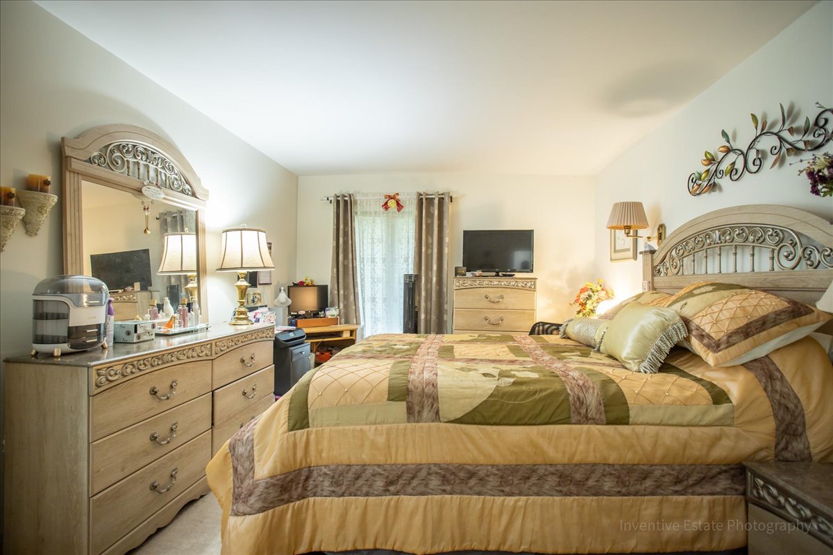 4224 Saratoga Avenue, Unit J105 Downers Grove, IL 60515 - Photo 13 of 20 a bedroom with a bed and flat screen tv