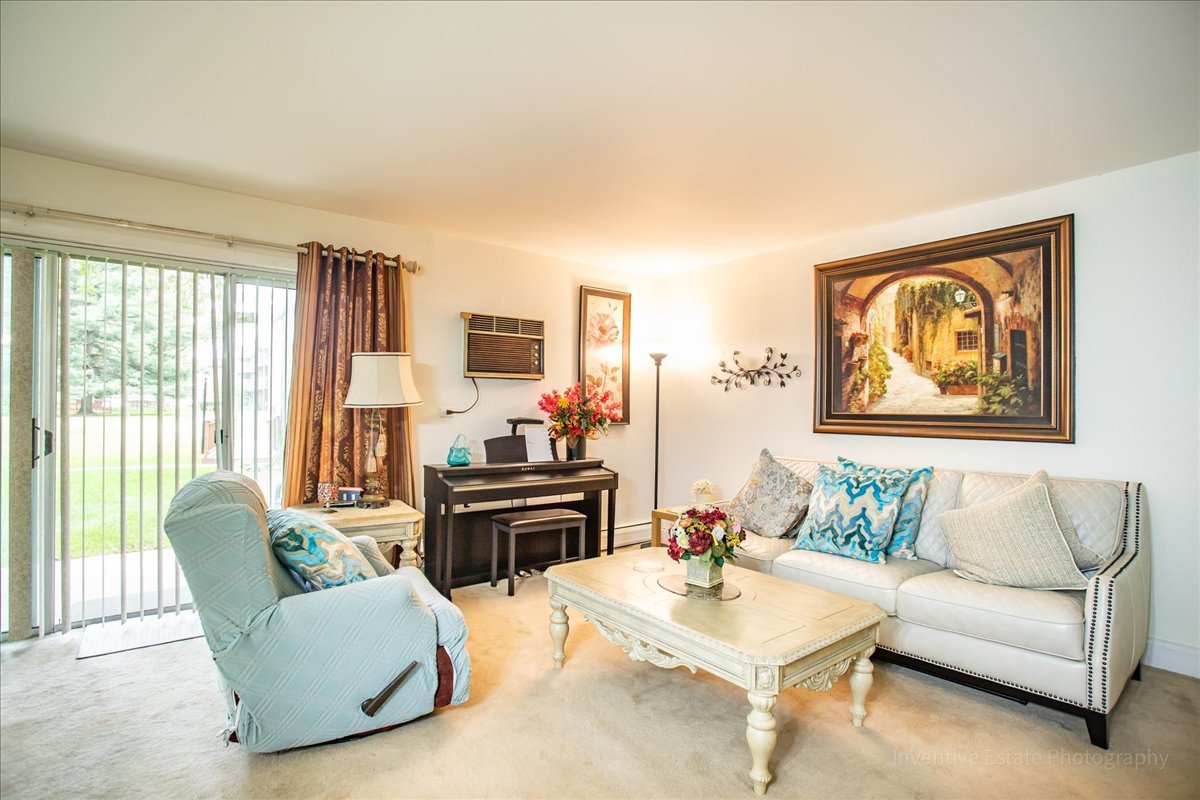 4224 Saratoga Avenue, Unit J105 Downers Grove, IL 60515 - Photo 3 of 20 a living room with furniture and a flat screen tv