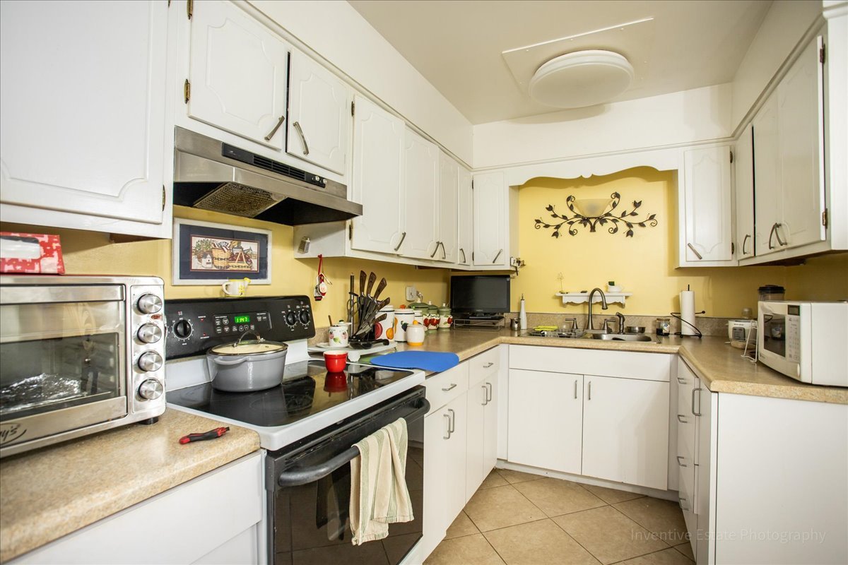 4224 Saratoga Avenue, Unit J105 Downers Grove, IL 60515 - Photo 9 of 20 a kitchen with stainless steel appliances granite countertop a stove and cabinets
