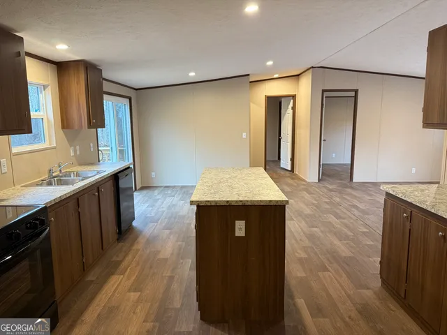 a kitchen with stainless steel appliances granite countertop a sink a refrigerator and a stove