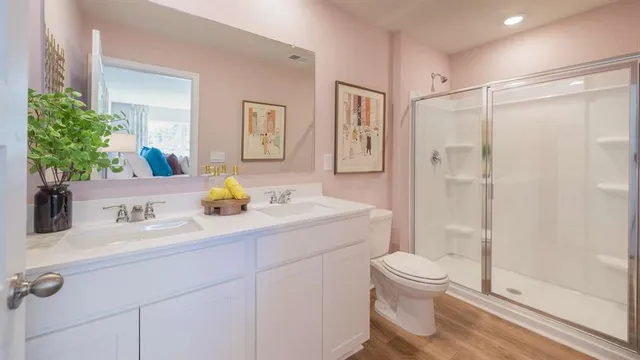 a bathroom with a double vanity sink toilet and shower