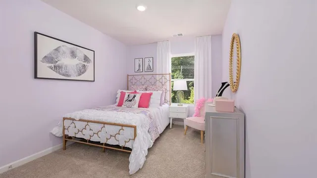 a bedroom with a bed a dresser with wooden floor