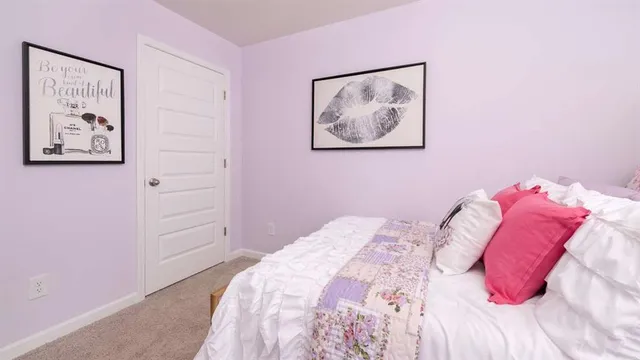 a bed room with a bed and a painting on the wall