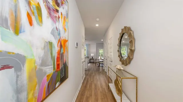 a view of a hallway with wooden floor and staircase