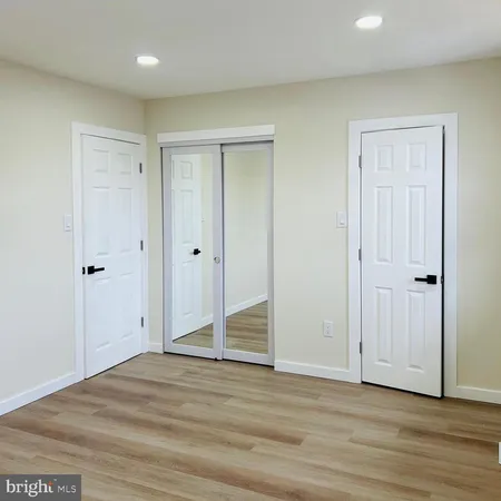 an empty room with wooden floor and white doors