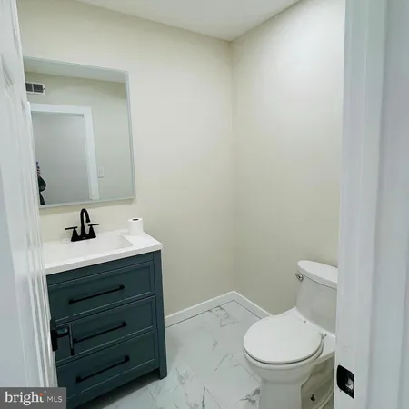 a bathroom with a toilet sink and mirror