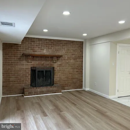 an empty room with wooden floor and fireplace