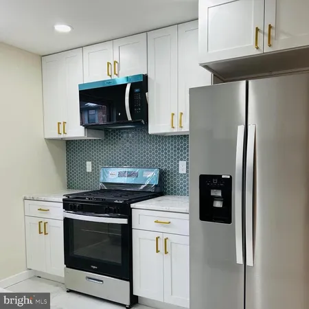 a kitchen with stainless steel appliances a stove microwave and sink