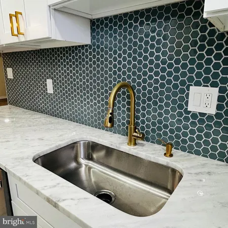 a kitchen with a sink and a black white cabinet