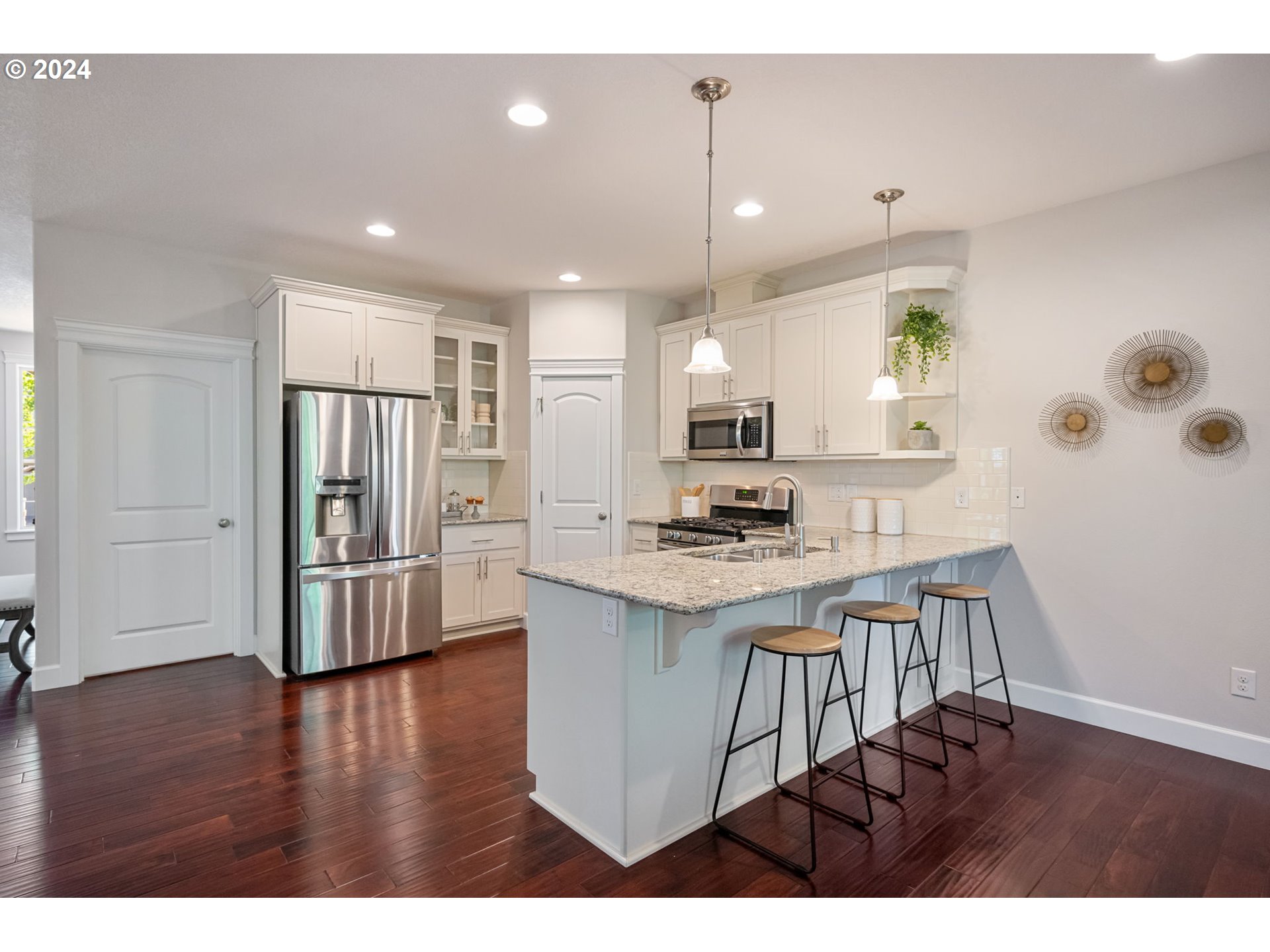 151 North 40th Avenue Ridgefield, WA 98642 - Photo 14 of 42 a open kitchen with stainless steel appliances granite countertop a refrigerator a stove a sink dishwasher and white countertops with wooden floor