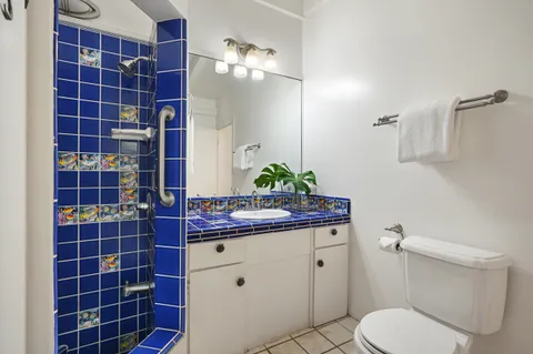 a bathroom with a granite countertop toilet a sink and mirror