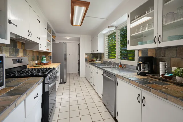 a large kitchen with stainless steel appliances granite countertop a stove and a sink