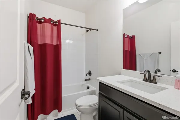 a bathroom with a sink a toilet and a large mirror