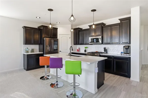 a kitchen with kitchen island granite countertop a sink cabinets and stainless steel appliances