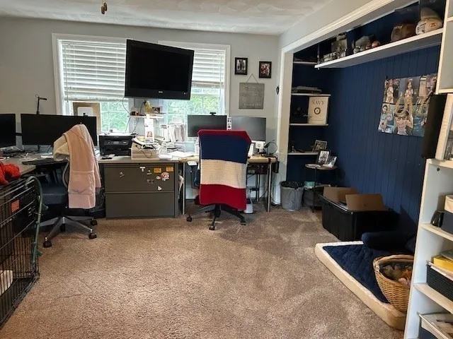 a view of a livingroom with workspace and a window