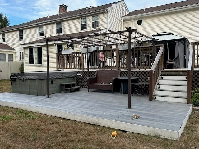 a view of a house with wooden deck and furniture