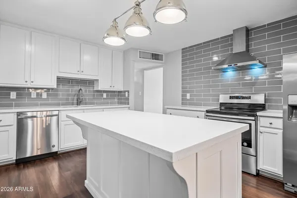 a kitchen with stainless steel appliances and white cabinets