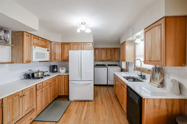 a kitchen with stainless steel appliances granite countertop a refrigerator a sink dishwasher a stove with wooden cabinets and floor