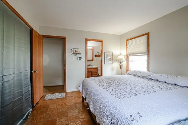 a spacious bedroom with a bed and a dresser next to a window