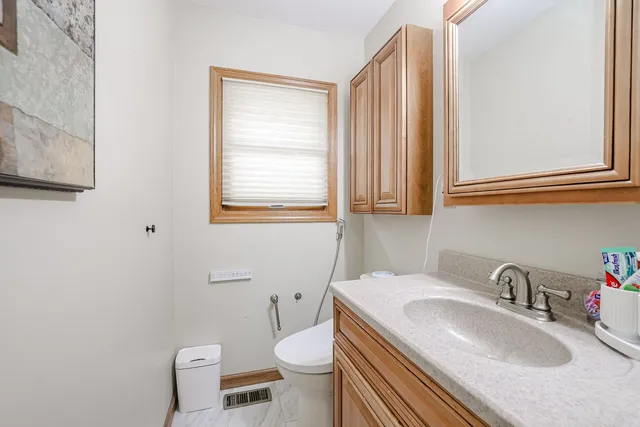 a bathroom with a granite countertop toilet sink and mirror