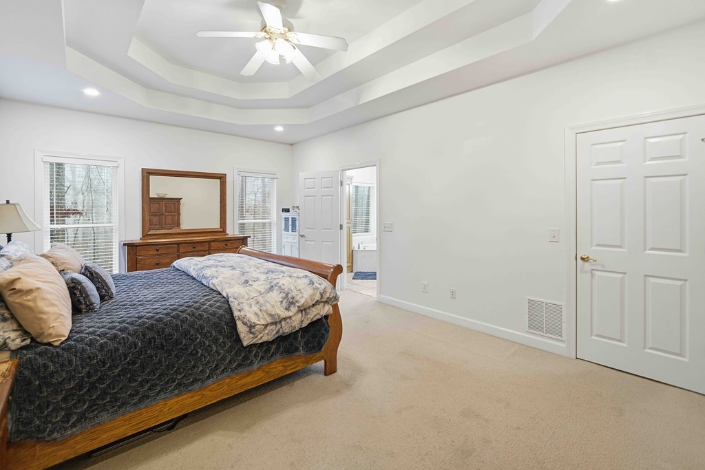 174 White Tail Ridge Road Jasper, GA 30143 - Photo 18 of 66 a bedroom with a large bed and a chandelier