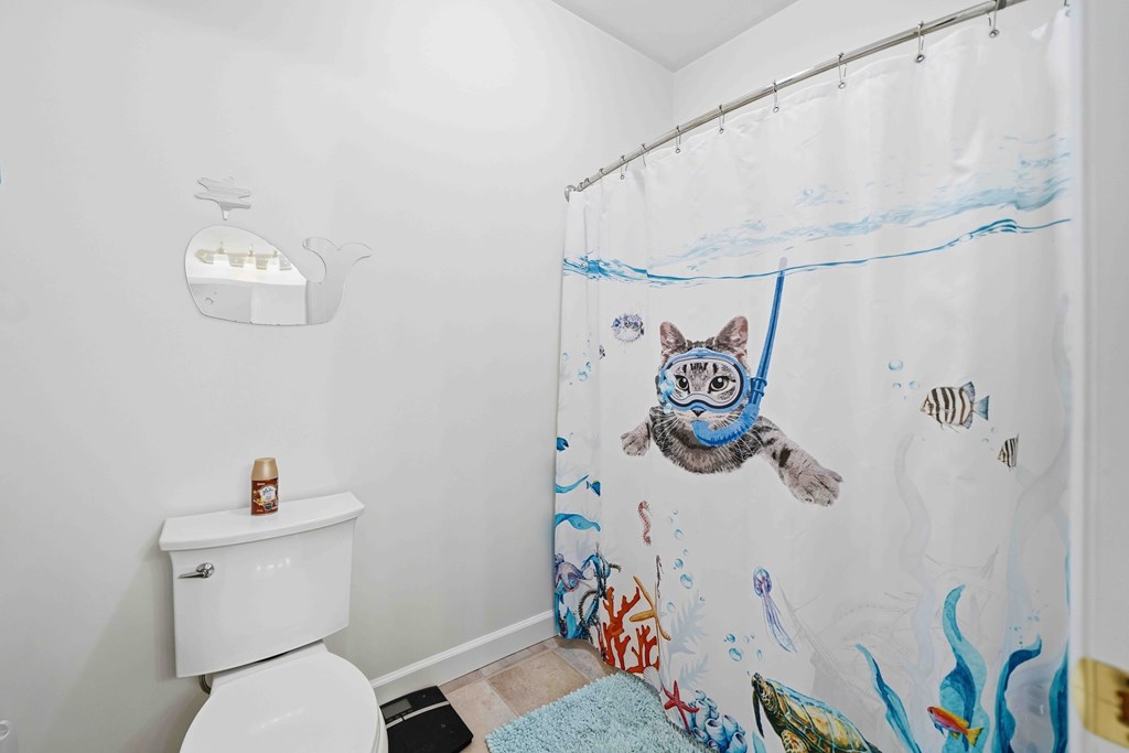 174 White Tail Ridge Road Jasper, GA 30143 - Photo 29 of 66 a bathroom with a toilet and a shower curtain