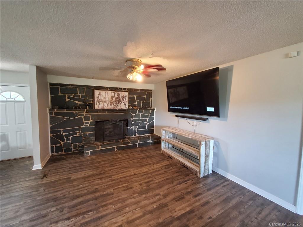 2415 Ruben Road Monroe, NC 28112 - Photo 29 of 42 a living room with furniture a flat screen tv and a fireplace