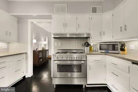 a kitchen with a stove and white cabinets