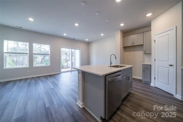 a kitchen with a sink and wooden floor
