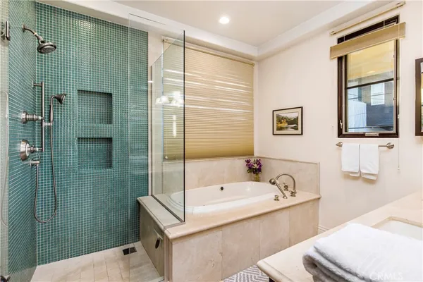 a bathroom with a tub sink and mirror