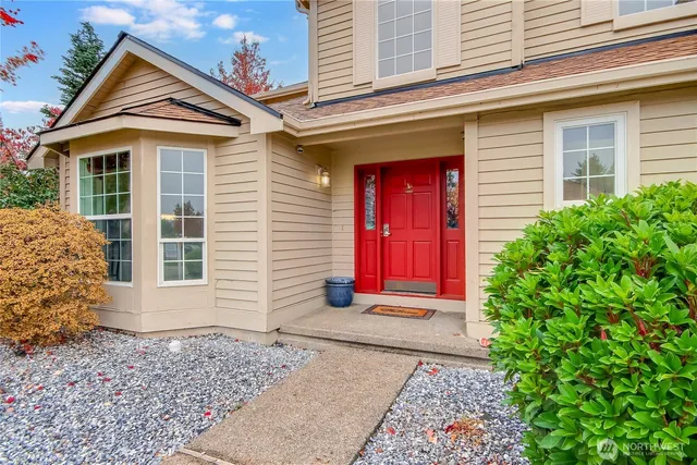 a view of a house with red door and tree