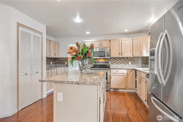 a kitchen with stainless steel appliances granite countertop a refrigerator and a sink