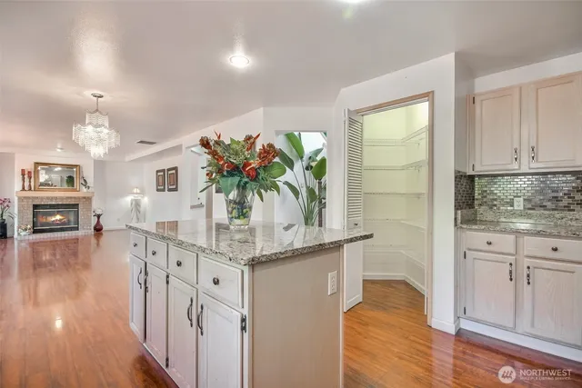 a kitchen with stainless steel appliances granite countertop a white cabinets stove and wooden floor