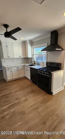 a kitchen with stainless steel appliances a stove a sink and white cabinets