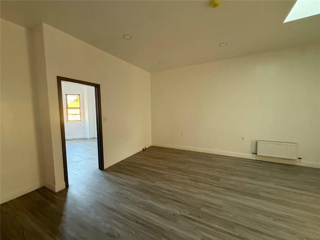 320 Bay Ridge Parkway Brooklyn, NY 11209 - Photo 9 of 10 a view of an empty room with wooden floor and a window