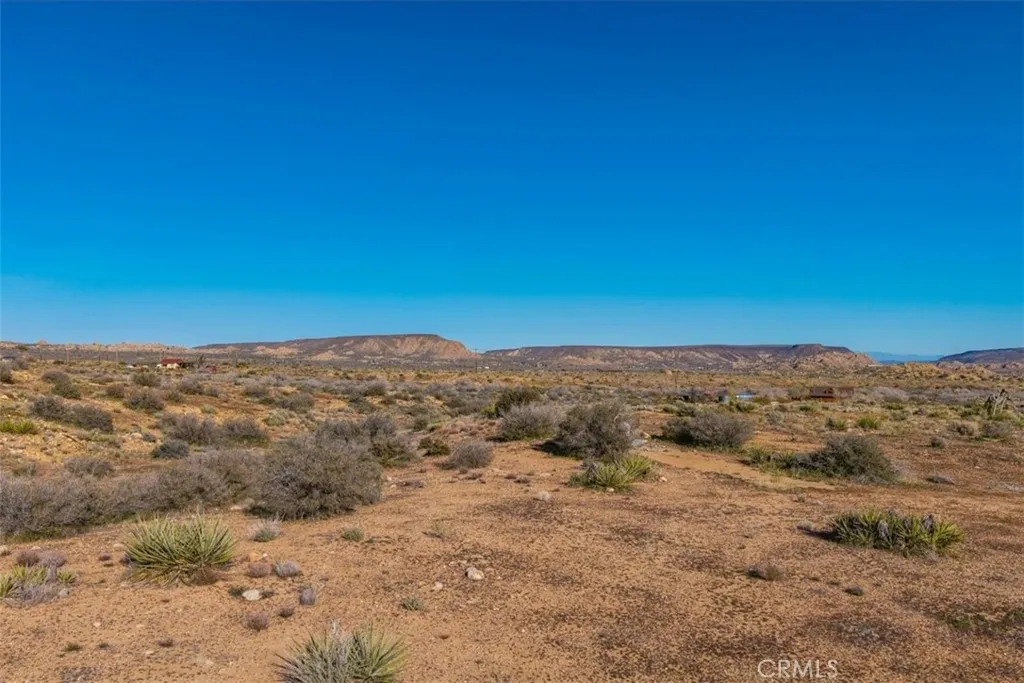 3263 Apache Pioneertown, CA 92268 - Photo 14 of 24 a view of a dry yard with mountains in the background