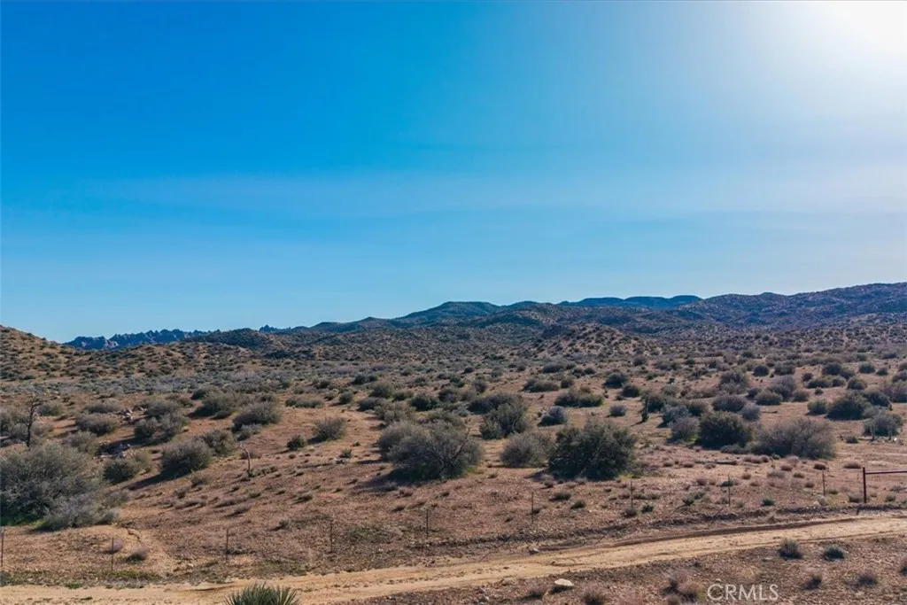 3263 Apache Pioneertown, CA 92268 - Photo 16 of 24 a view of a dry yard with mountains in the background