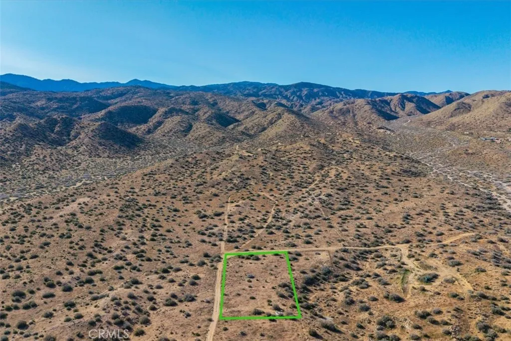 3263 Apache Pioneertown, CA 92268 - Photo 4 of 24 a view of a dry yard with mountains in the background