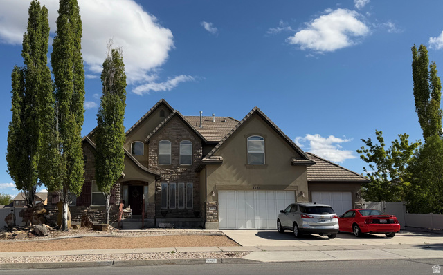 3323 Water Street Riverton, UT 84065 - Photo 1 of 1 View of front of home with stucco siding, stone siding, concrete driveway, a tile roof and an attached garage