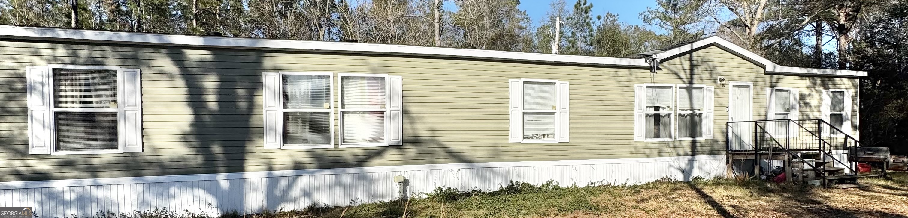 a view of a house with a small yard and floor to ceiling window