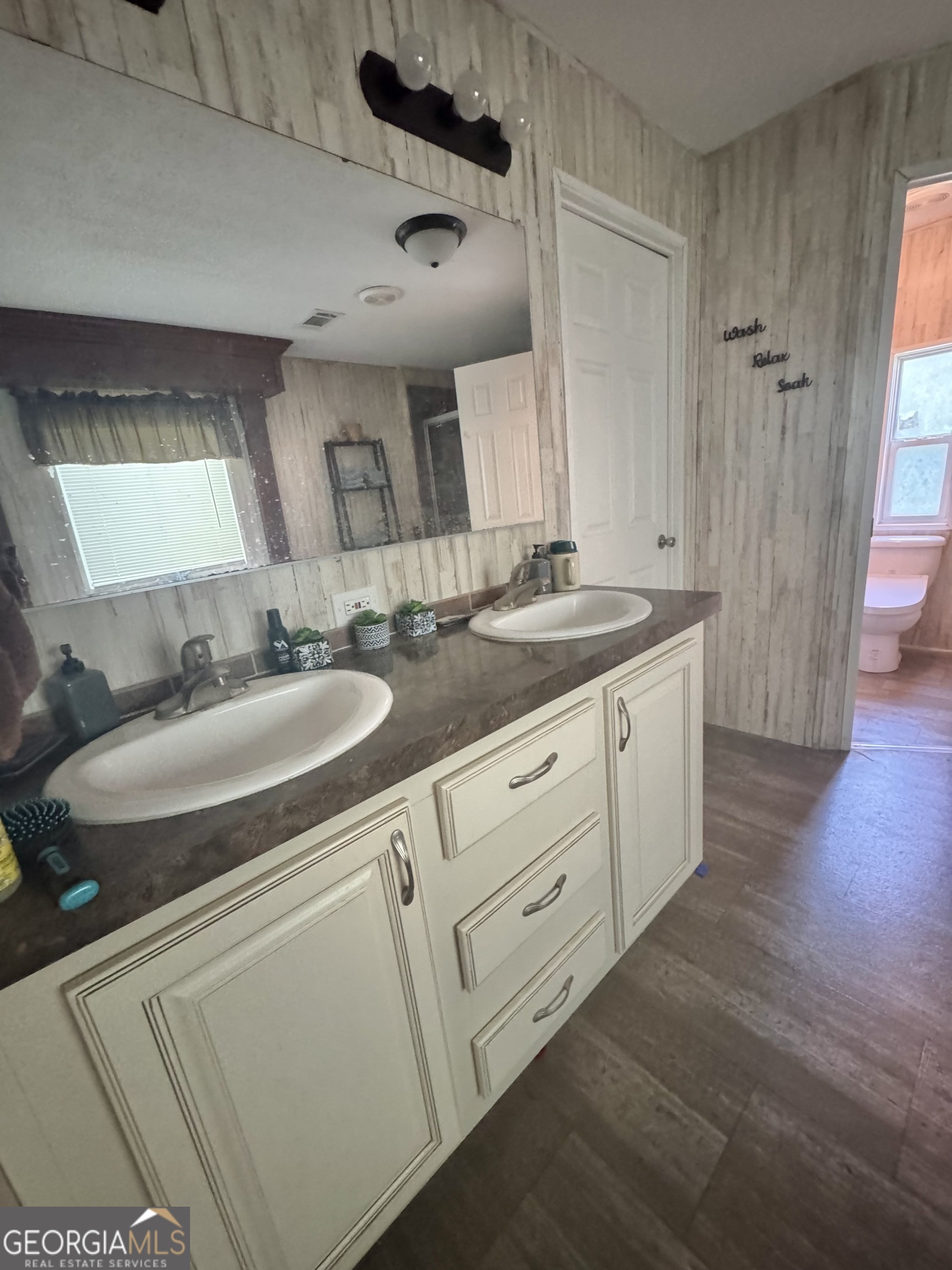 92 Graham Lane Claxton, GA 30417 - Photo 10 of 20 a bathroom with a double vanity sink a mirror and a shower
